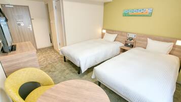 A hotel room with two beds, a desk, a chair, and a small table.