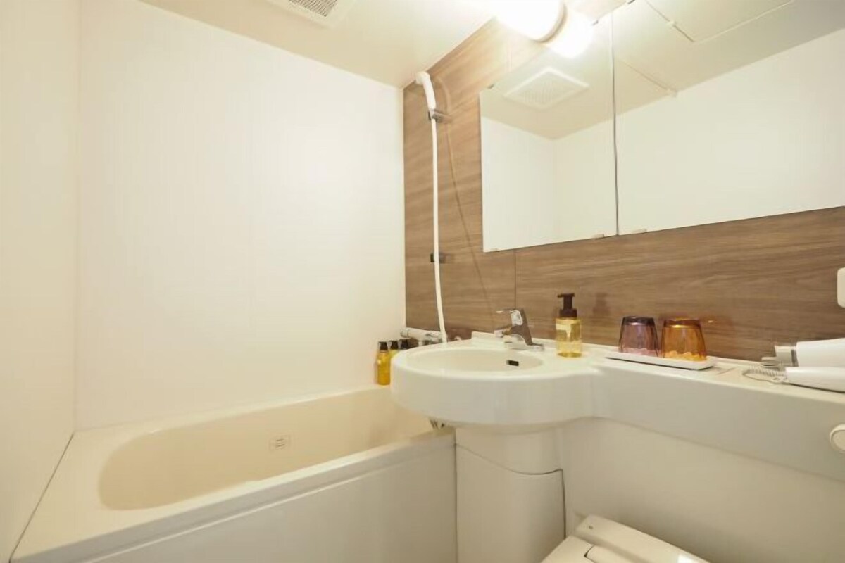 Une salle de bain moderne avec une baignoire, un lavabo et un miroir.