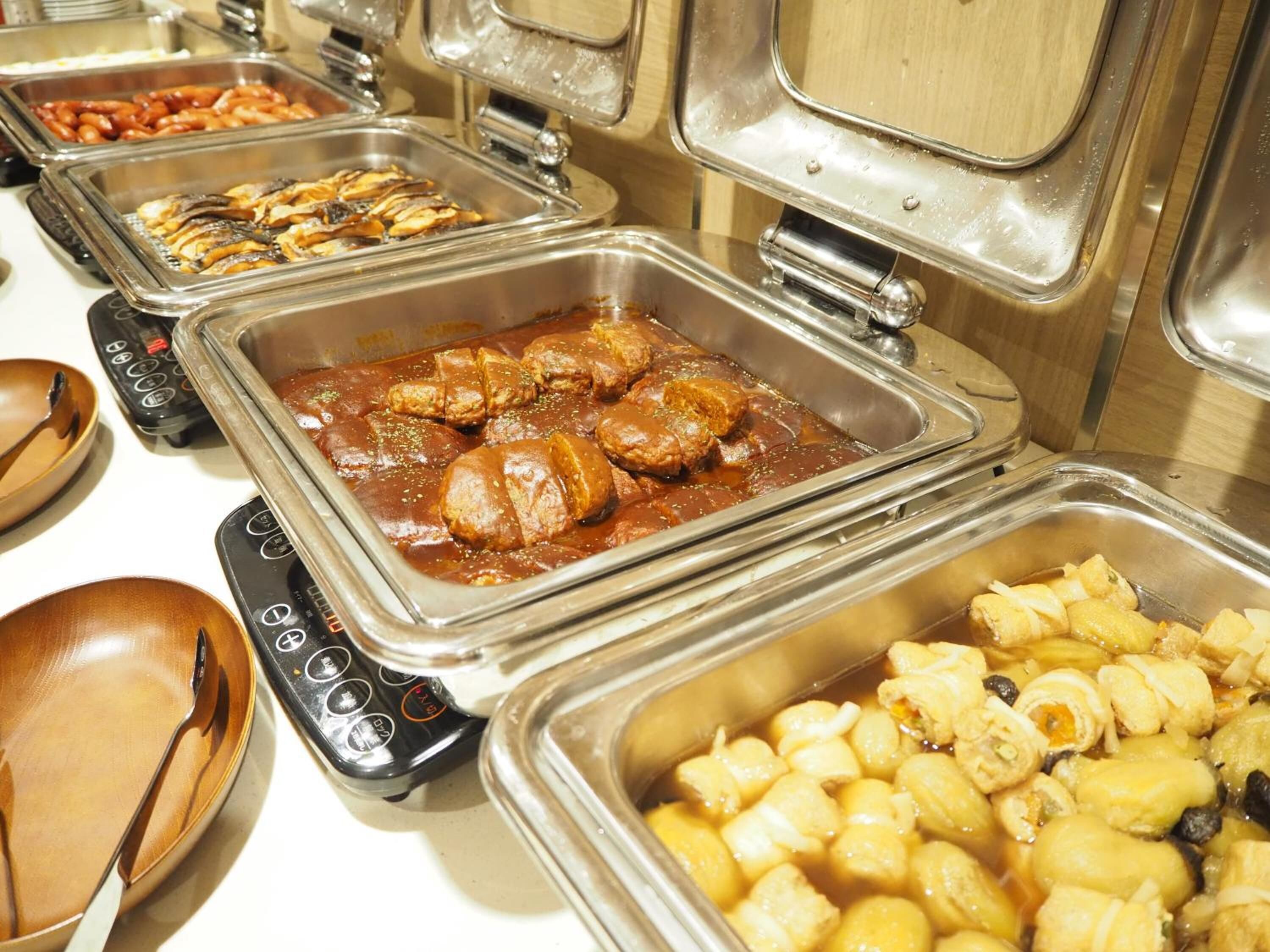 A buffet with various food items including meats, vegetables, and fruits.