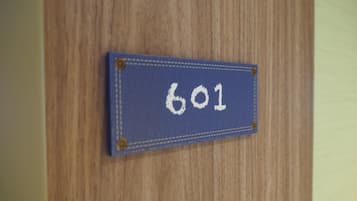 Um sinal azul com o número 601 numa porta de madeira.