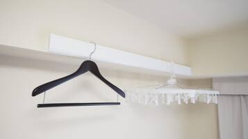 A room with a white wall, a black hanger, and a white curtain.