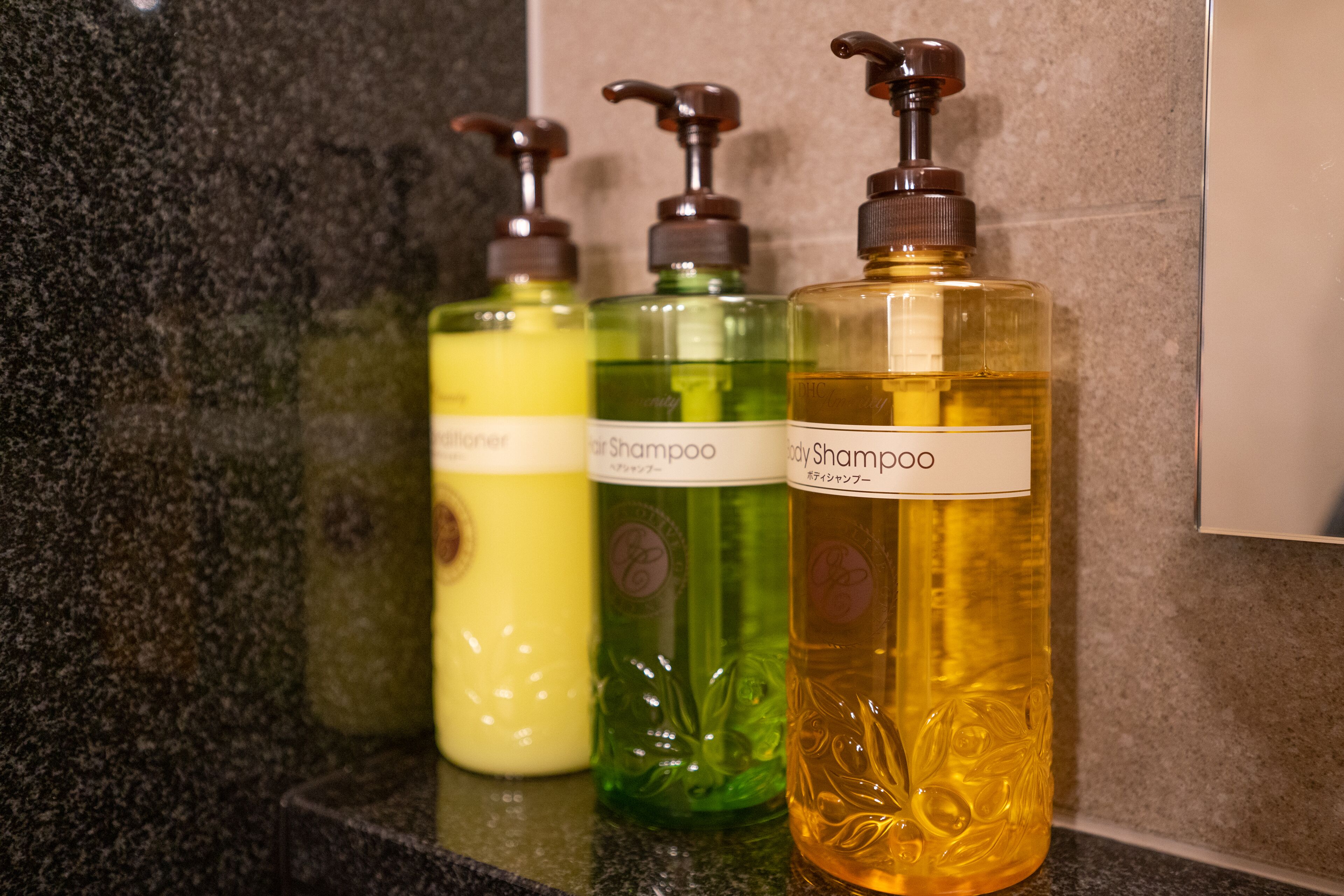 Three bottles of shampoo on a countertop.