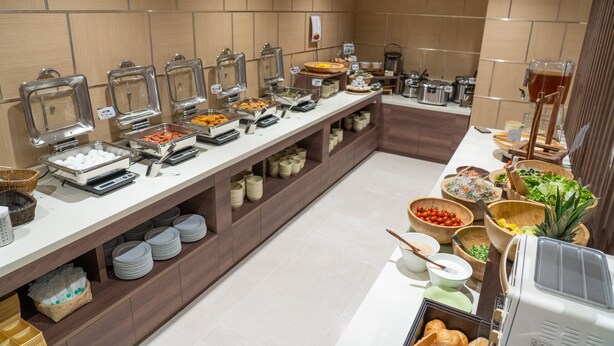 Ein Buffet mit verschiedenen Speisenstationen und einer Kaffeemaschine.