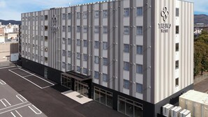 Ein modernes Hotelgebäude mit einem Fenstergitter und einer flachen Dachkonstruktion.