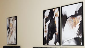 A modern bedroom with a large bed, multiple pillows, a black headboard, and abstract artwork on the wall. - Watford WD17 - Stunning 2 Bed Flat near Watford Junction (Watford)