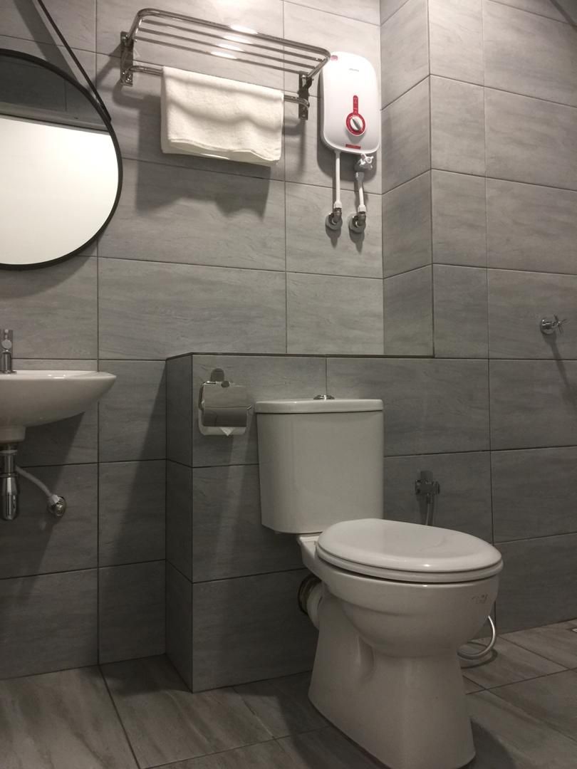 A modern bathroom with a toilet, sink, and towel rack.
