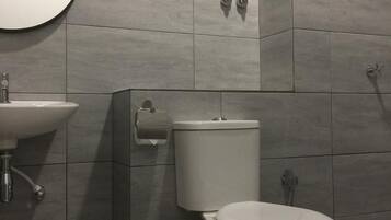 A modern bathroom with a toilet, sink, and towel rack.