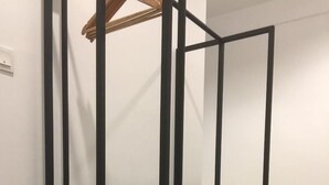 A room with a bed, a black metal partition, and a wooden floor. - Urban Inn Alor Setar (Alor Setar)