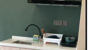 A kitchen with a sink, countertop, cabinets, and a stove. - Urban Inn Alor Setar (Alor Setar)