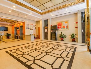 A spacious lobby with a geometric patterned floor, elevators, a reception desk, and potted plants. - eStay Residence - Guangzhou Peace World Plaza (Guangzhou)