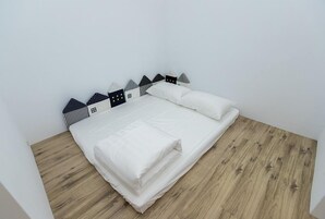 Una cama bien tendida con sábanas blancas y cabecera de madera.