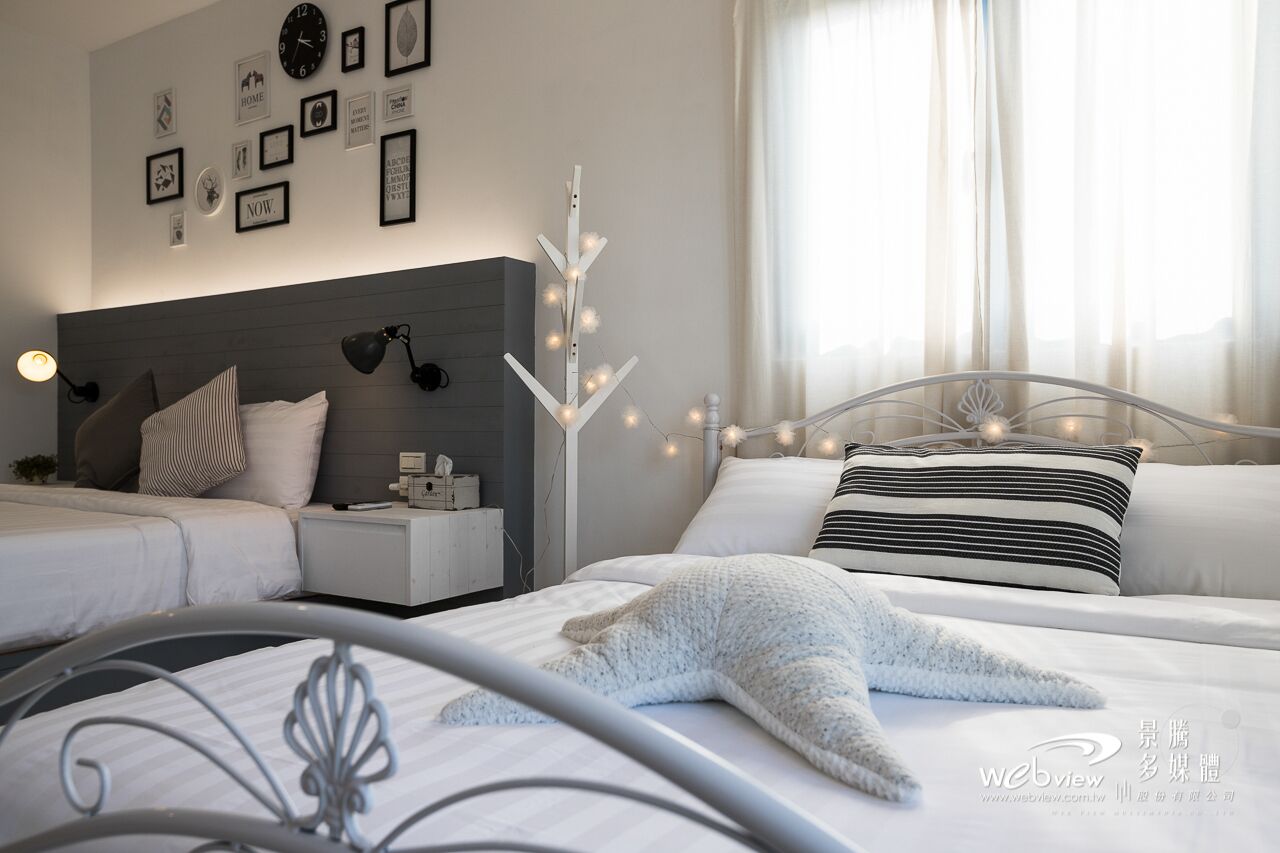 Una habitación de hotel moderna con una cama grande, una mesita de noche, una l ámpara y un reloj de pared.