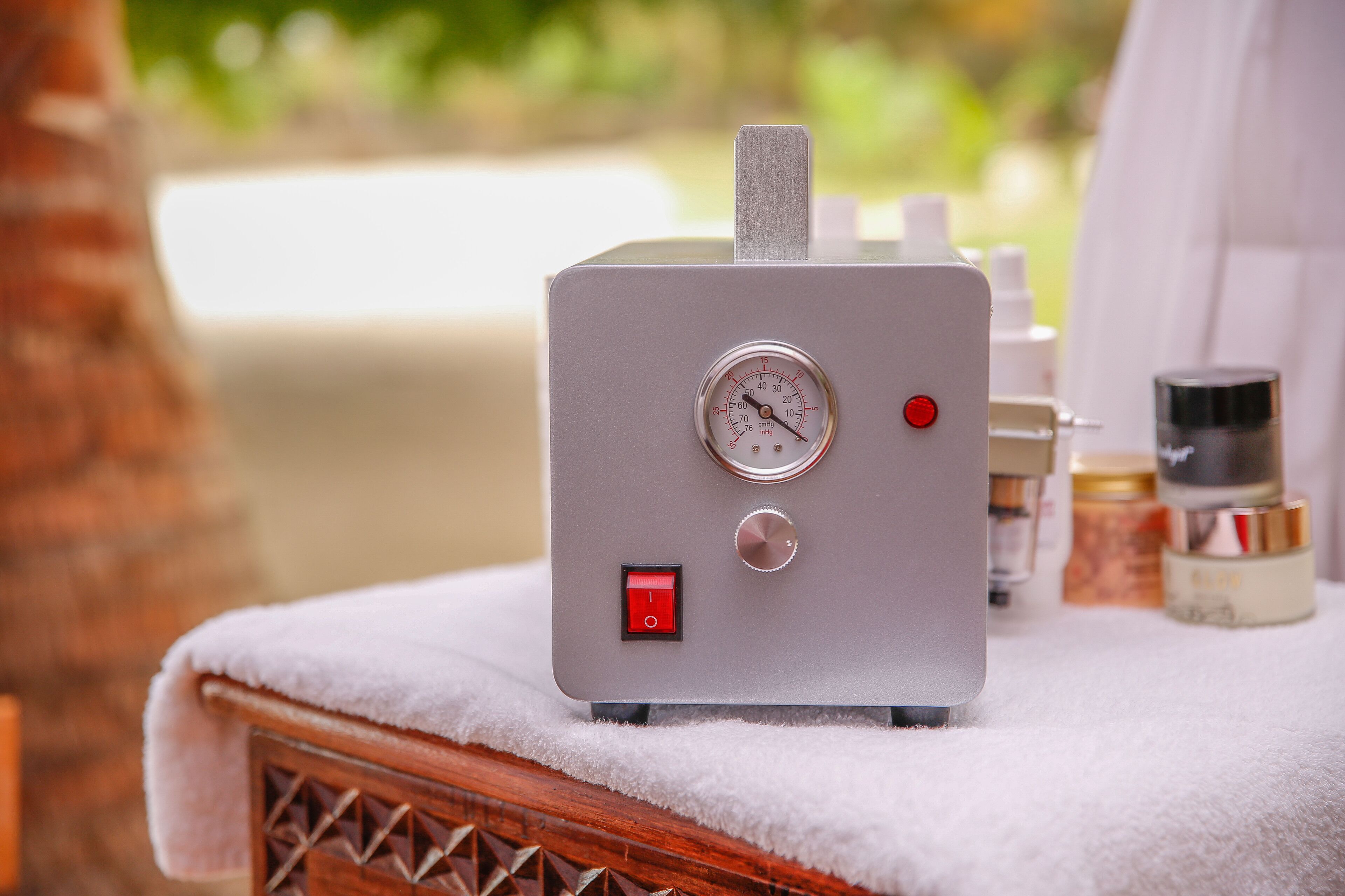 Uma sauna portátil com mostrador digital, painel de controle e uma toalha sobre um banco de madeira.