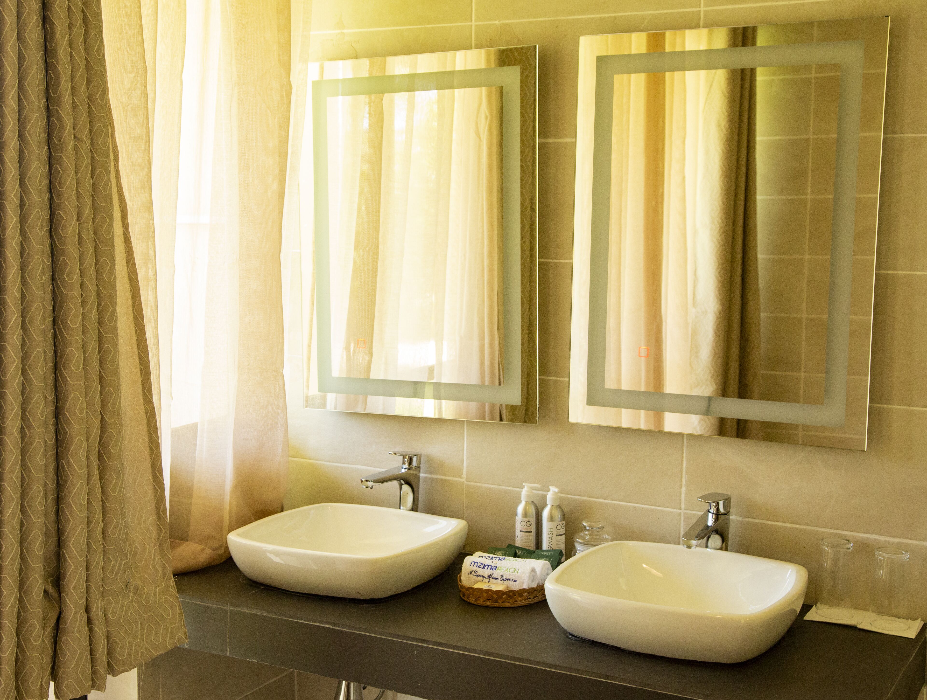 A bathroom with two sinks, a mirror, and a towel rack.