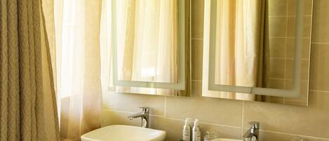 A bathroom with two sinks, a mirror, and a towel rack.