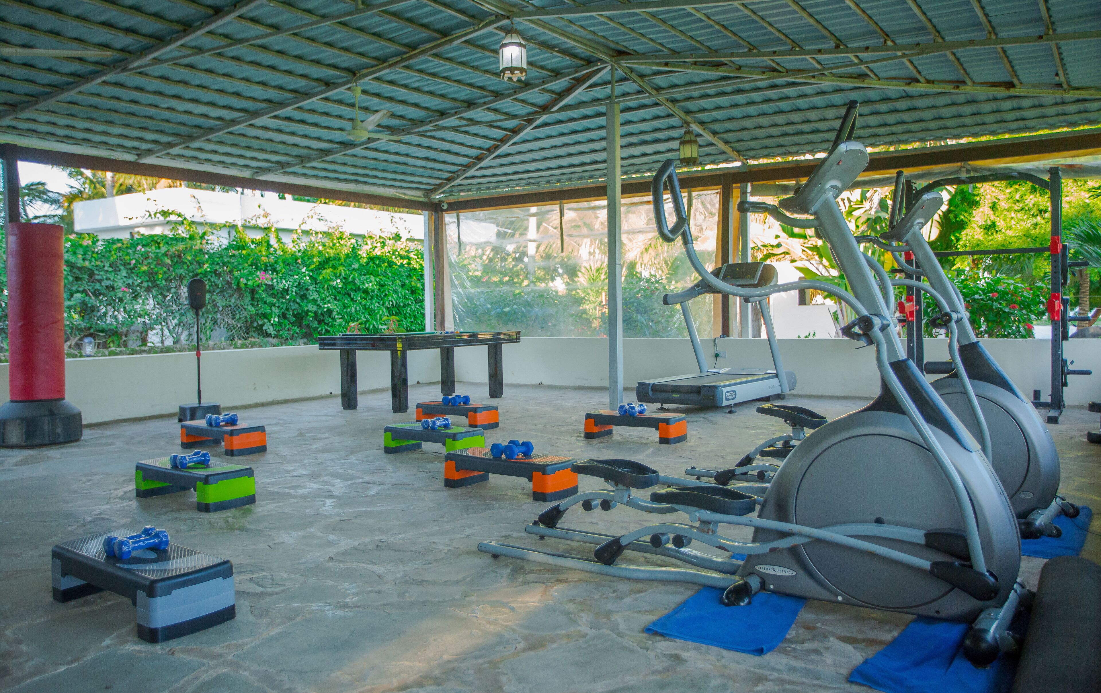An indoor gym with exercise equipment, a table, and exercise balls.