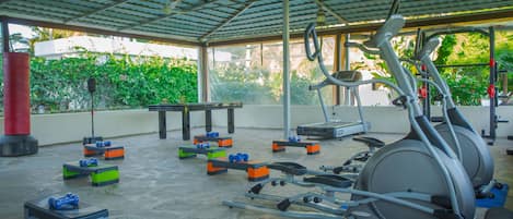 An indoor gym with exercise equipment, a table, and exercise balls.