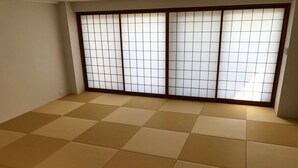 A room with tatami mat flooring and a shoji screen wall. - Enzo Uno D (Tamano)