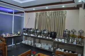 A buffet setup with various food and drink dispensers, plates, and cups. - Royal Landmark Hotel (Yangon)