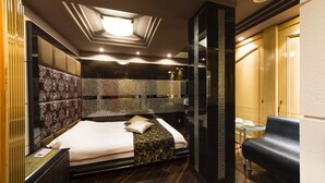 A modern hotel room with a large bed, a seating area, and a decorative ceiling. - HOTEL APiO - Adults Only (Tokyo)