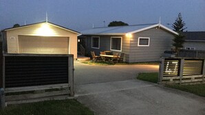 Een woonhuis met een garage, een overdekt terras en een gazon.