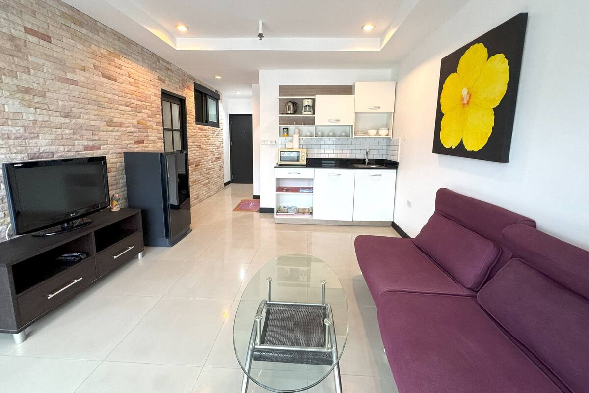 A modern living room with a TV, sofa, and coffee table.
