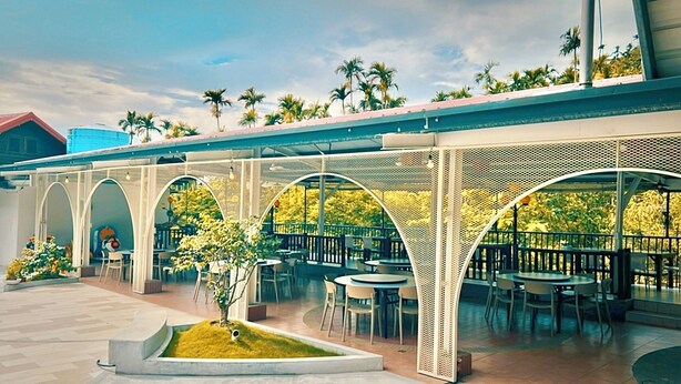 Un patio al aire libre con zona de estar cubierta y un pequeño jardín.