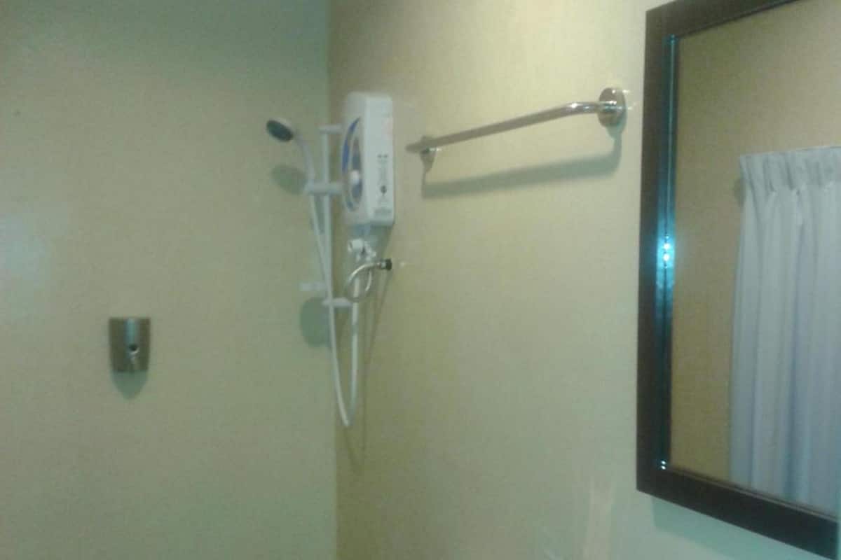A bathroom with a shower, a towel rack, and a mirror.