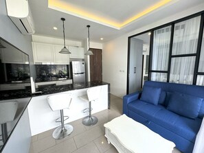 Appartement Deluxe, 1 chambre, vue piscine | Coin séjour | Télévision à écran plat de 43 pouces avec chaînes par câble