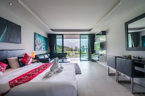 Quarto de hotel moderno com uma cama grande, um sofá, uma escrivaninha e vista para o exterior.
