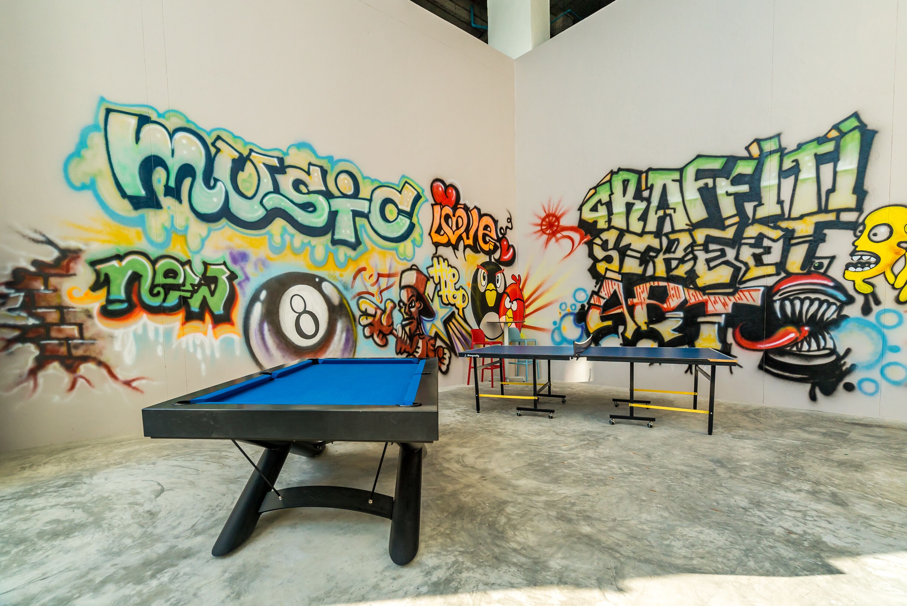 A billiards table in a room with graffiti art on the walls.