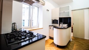 A modern kitchen with a gas stove, microwave, and built-in oven. - Kopernika Srodmiescie Apartment (Warsaw)