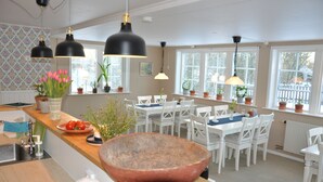 Een keuken met witte stoelen, een houten aanrecht en een grote kom.