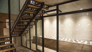 A modern staircase with wooden steps and metal railings, leading to a glass door. - History of Tbilisi (Tbilisi)