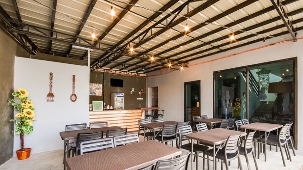 A spacious indoor dining area with multiple tables and chairs, a bar counter, and a large window providing natural light. - Super OYO 495 The Pocket Hotel (Lapu-Lapu)