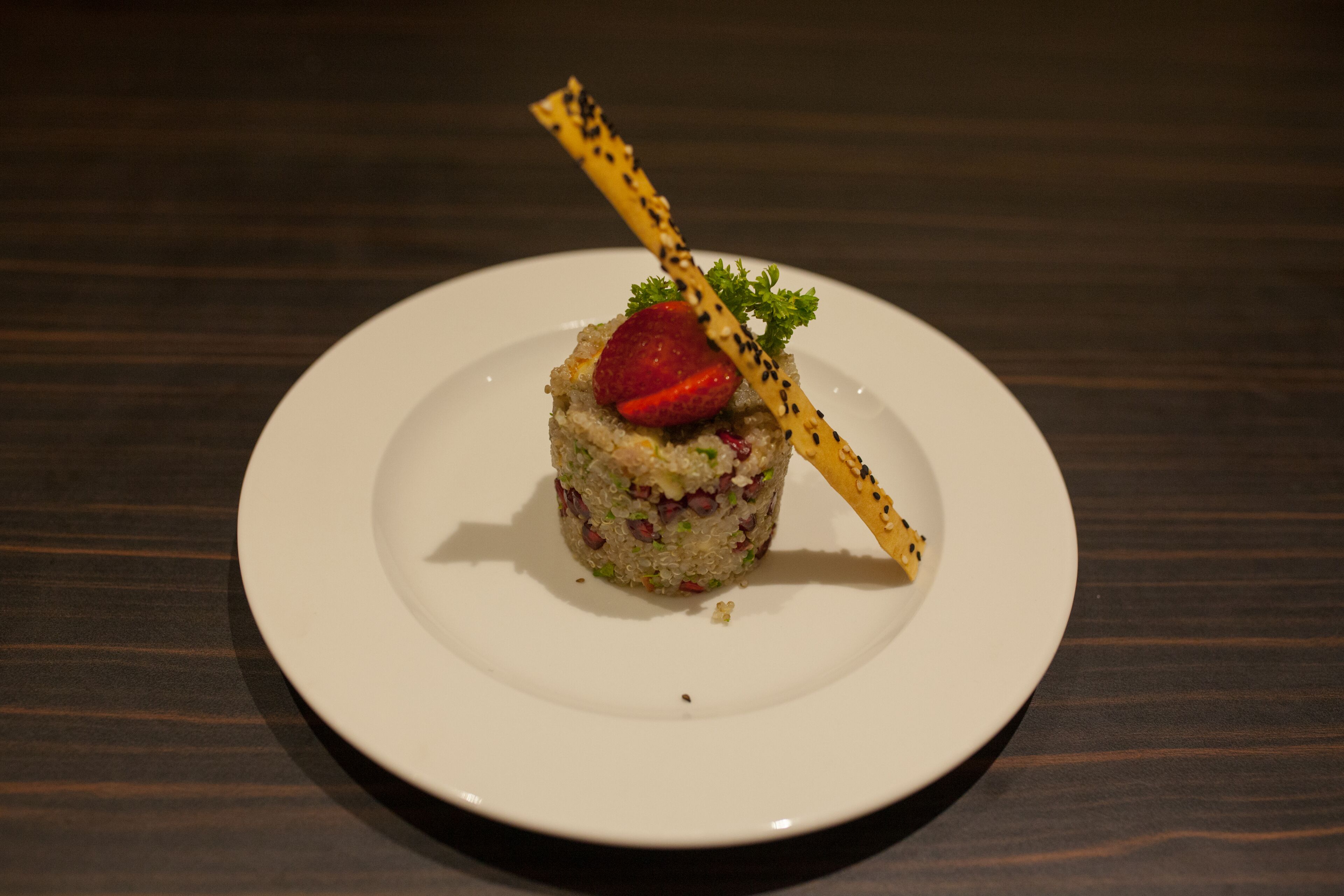 Un plato blanco con comida sobre una mesa de madera.