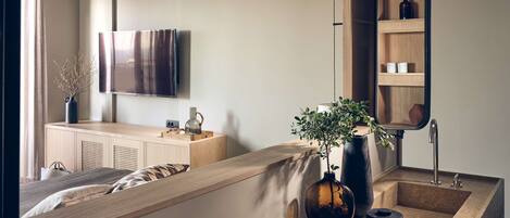 A modern bedroom with a bed, bedside table, and a large mirror.