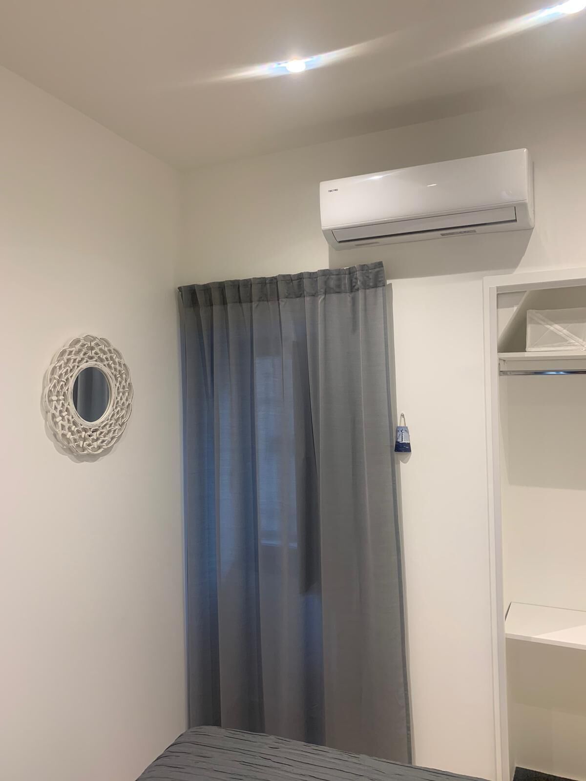 Ein Zimmer mit einem Bett, einem Kleiderschrank und einer Wand-Klimaanlage.