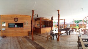 Un interior de madera con barra, mesas y sillas.