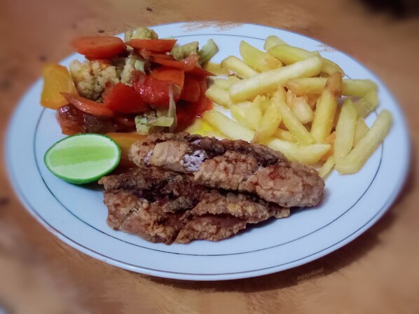 A plate with fried chicken, French fries, and a side of mixed vegetables.