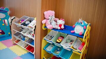 Zona de juegos infantil con un mueble de almacenamiento de varios niveles y un coche de juguete.