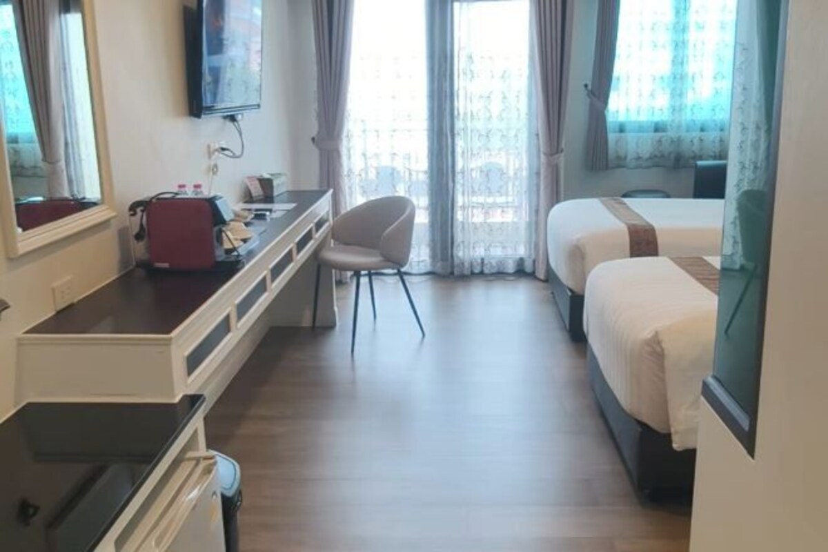 Een hotelkamer met een bed, een bureau, een stoel en een televisie.