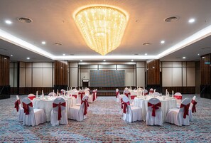 A banquet hall with round tables, white tablecloths, and red sashes. - Travelodge Ipoh (Ipoh)