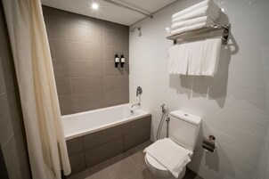 Un baño moderno con bañera, inodoro y toallero.