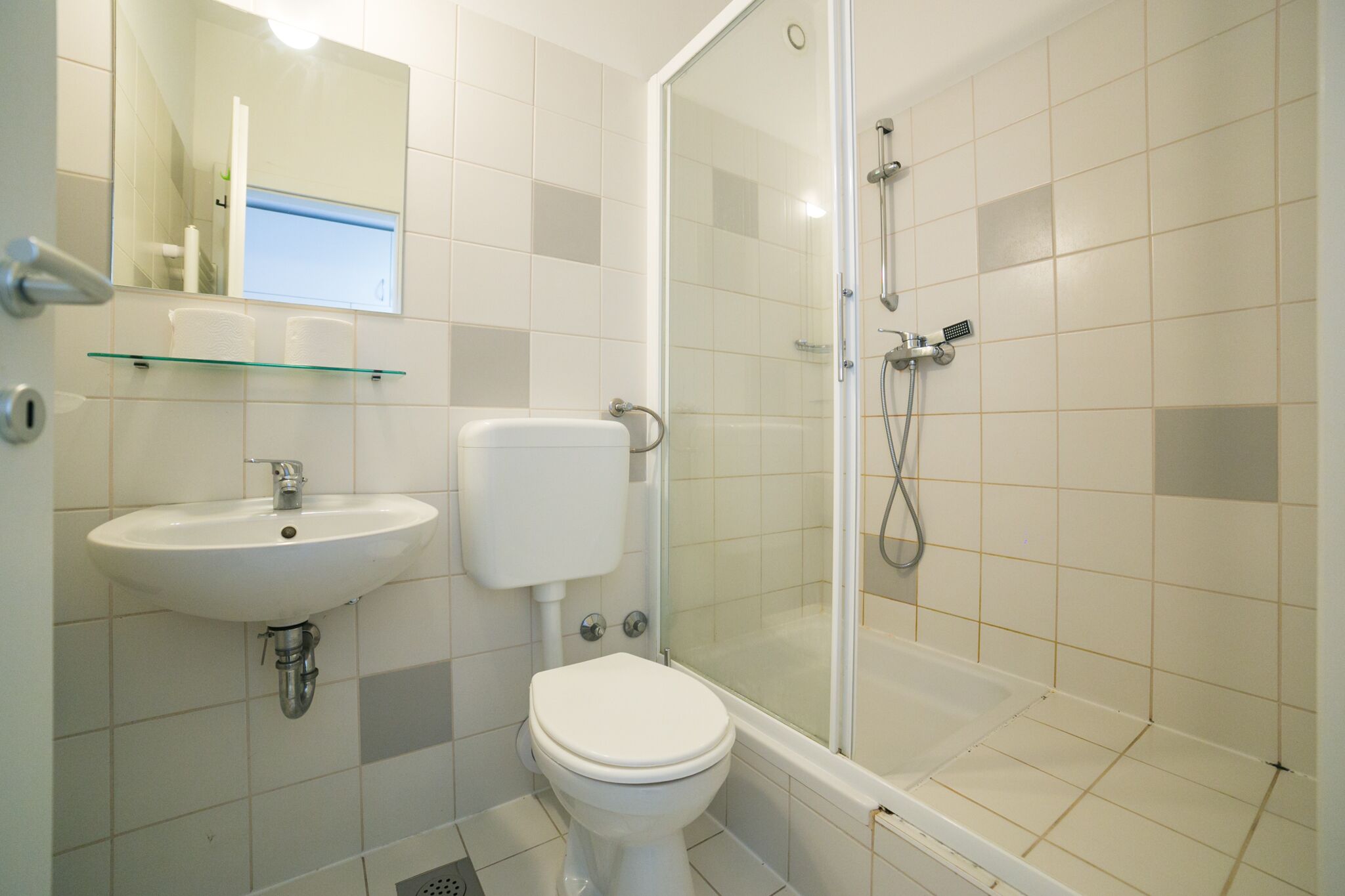 A bathroom with a toilet, sink, and shower.