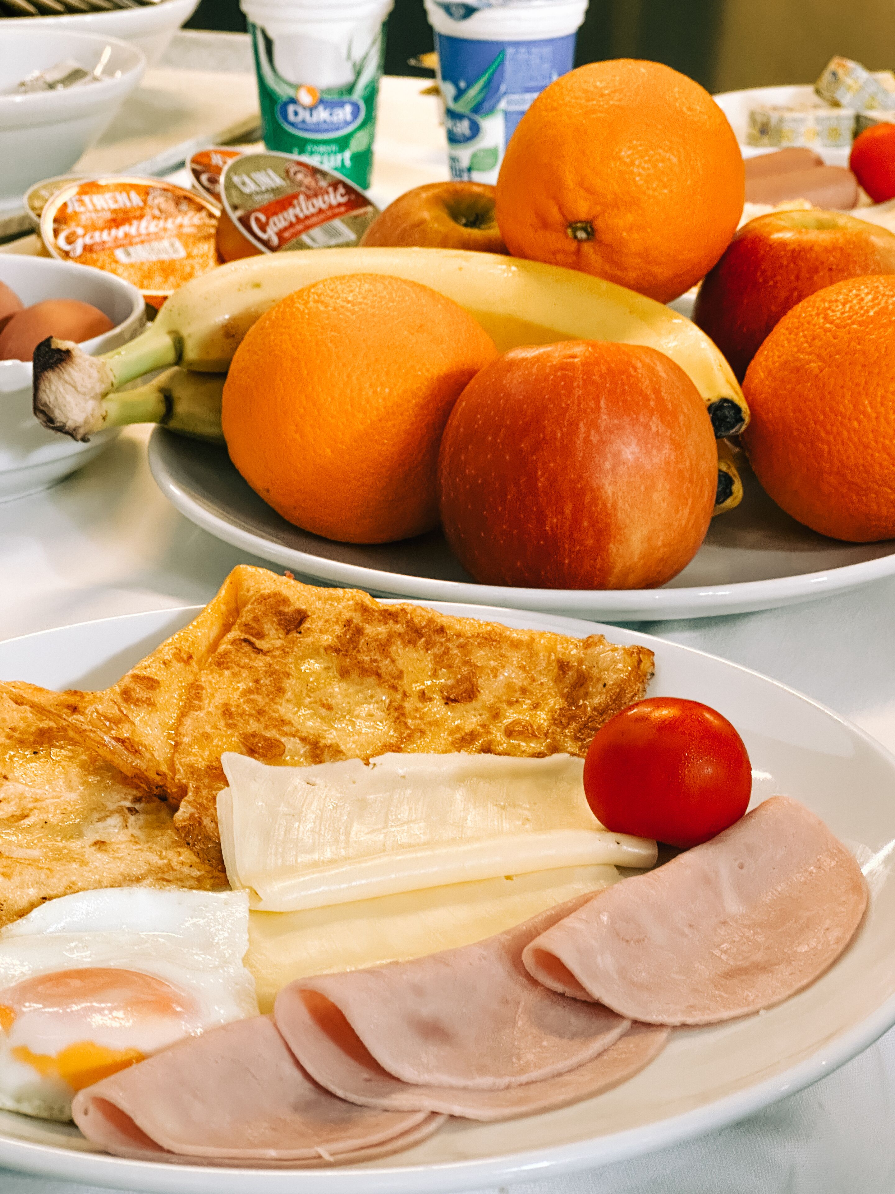 A breakfast plate with eggs, ham, cheese, and tomatoes.