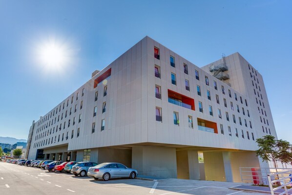 A modern building with a parking lot in front. - Rooms Dr. Franjo Tuđman - Hostel (Split)