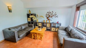 A living room with a sofa set, a wooden table, and a decorative tree wall piece. - Casa Diego Piña Júzcar by Ruralidays (Málaga)