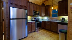 A modern kitchen with wooden cabinets, stainless steel appliances, and a granite countertop.