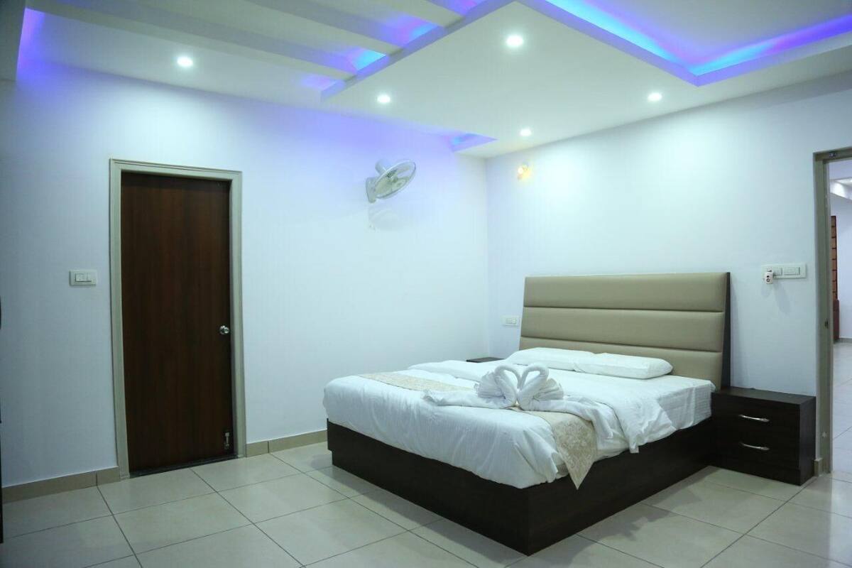 A bedroom with a bed, bedside table, and a ceiling fan.